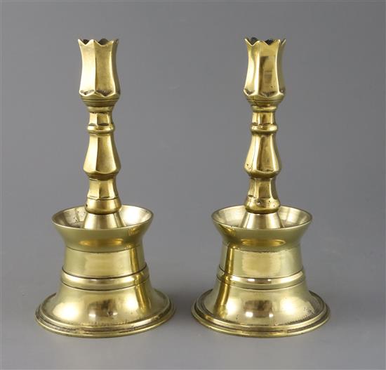 A pair of 17th century Ottoman brass bell based candlesticks, H.9in.